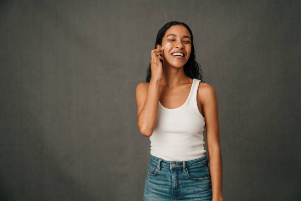 istock Smiling African American applying face cream to her face 1408184298