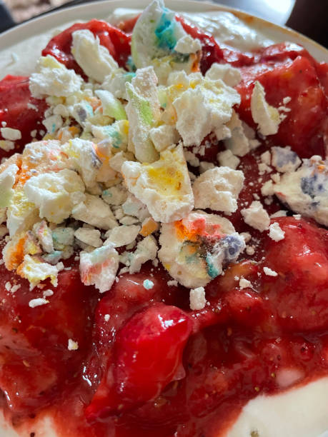 Full frame image of Eton mess dessert, strawberries, cream, meringue, mixed together, crumbled rainbow meringue kisses, elevated view