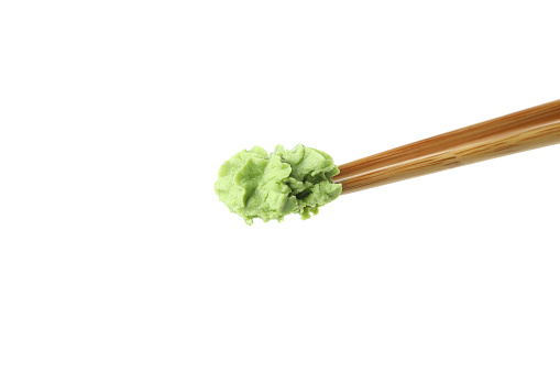 Chopsticks with wasabi isolated on white background