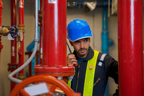 Engineer is working on the roof of building. Surrounding with high building. Engineer is working on the roof of building. Surrounding with high building. Construction, engineer and city concept. basement construction site construction blueprint stock pictures, royalty-free photos & images