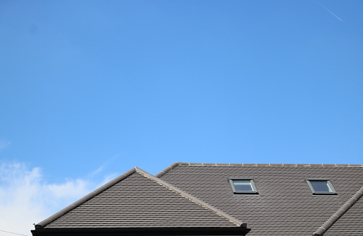 Contemporary grey house roof against blue sky with copy space