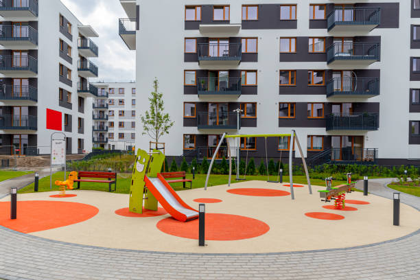 Outdoor playground for children on housing estate with modern residential apartment buildings. New block of flats stock photo