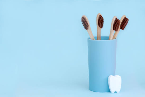 istock Bamboo toothbrushes and a white tooth on a blue background. Place for text. Background 1408194160