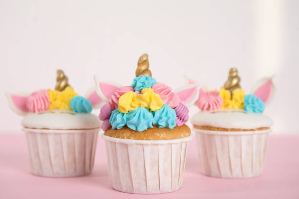 istock Three cute sweet unicorn cupcakes on pink table 1408195461