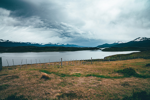 Patagonian landscape with Beagle Channel and snowcapped mountains in the background. Cloudy day.