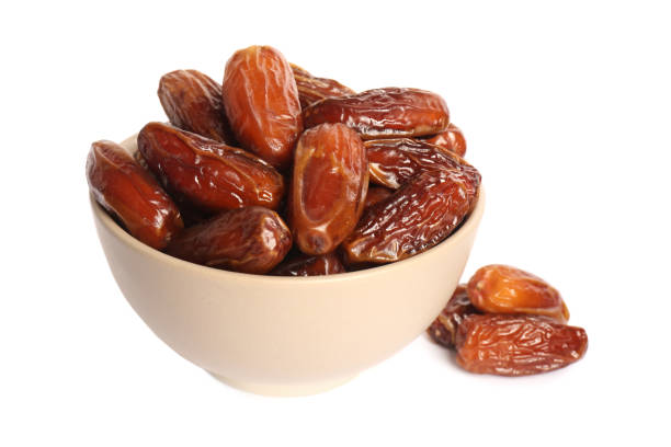 istock Sweet dried dates in bowl on white background 1408198859