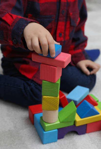 istock Little child playing with building blocks on carpet, closeup 1408198886