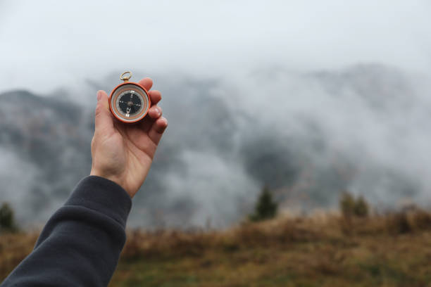 istock Woman using compass during journey in mountains, closeup. Space for text 1408198930