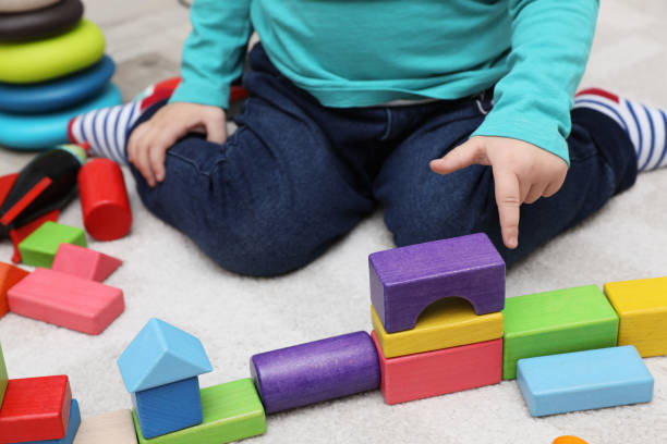 istock Little child playing with building blocks on carpet, closeup 1408198946