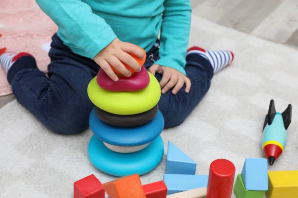 istock Little child playing with stacking toy on carpet, closeup 1408198950