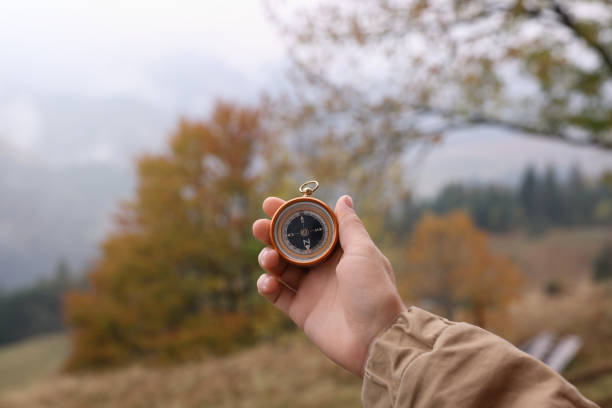 istock Woman using compass for navigation during journey in mountains, closeup 1408198953