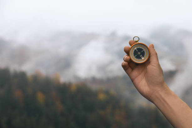 istock Woman using compass during journey in mountains, closeup. Space for text 1408198971