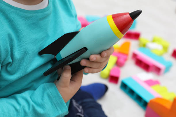 istock Little child playing with toy rocket indoors, closeup 1408198990