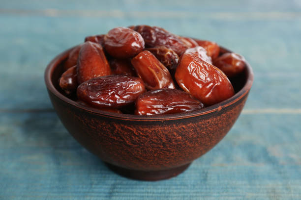 istock Sweet dried dates in bowl on light blue wooden table 1408199014