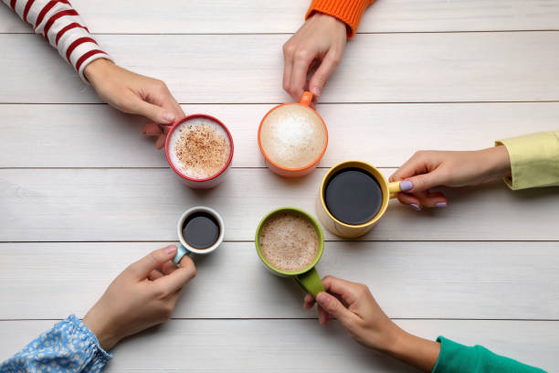 istock People holding different cups with aromatic hot coffee at white wooden table, top view 1408199083
