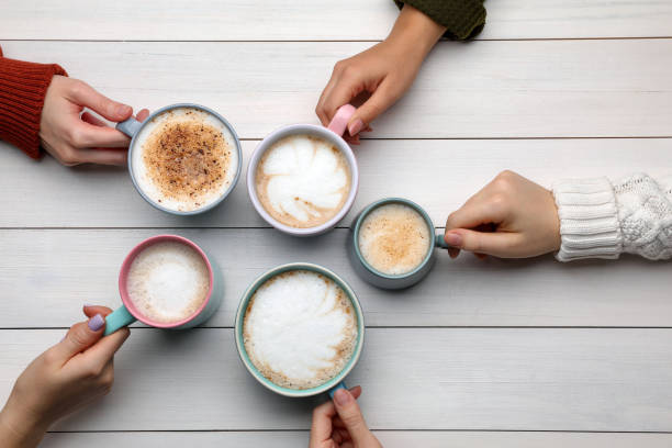 istock People holding different cups with aromatic hot coffee at white wooden table, top view 1408199089