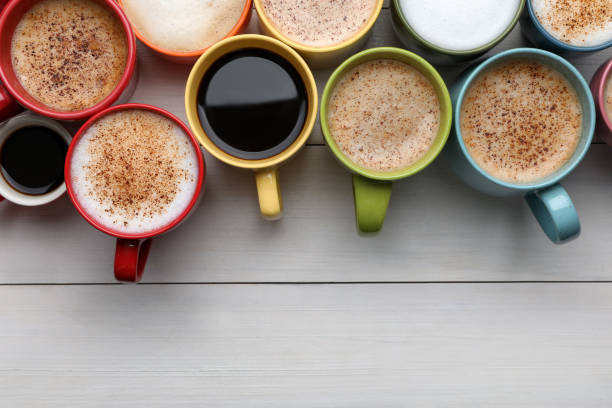 istock Many different cups with aromatic hot coffee on white wooden table, flat lay. Space for text 1408199102