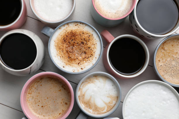 istock Many different cups with aromatic hot coffee on white wooden table, flat lay 1408199106