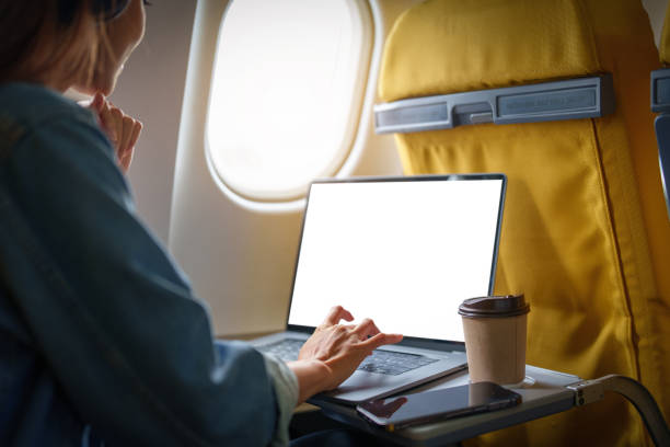 istock An Asian woman sits in a window seat in Economy Class using a white screen laptop computer that can use text or advertising while in flying. Travel, vacation 1408199109