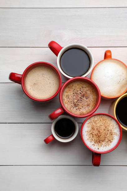 istock Many different cups with aromatic hot coffee on white wooden table, flat lay 1408199129