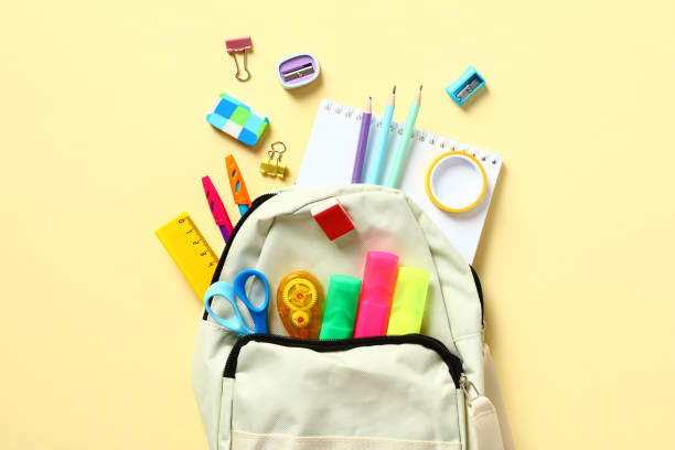 istock Backpack with colorful school supplies on yellow table, top view. Back to school concept. Flat lay, top view. 1408199944