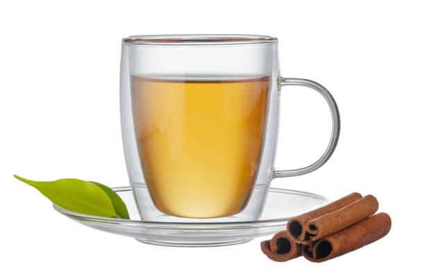 istock Glass cup of tea and cinnamon sticks isolated on white 1408200192