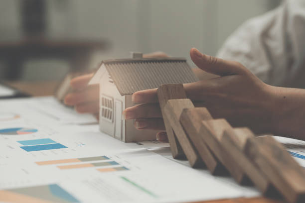 istock Real estate and insurance concept. Agent using hand symbol to protect risk might happen to house. 1408201467