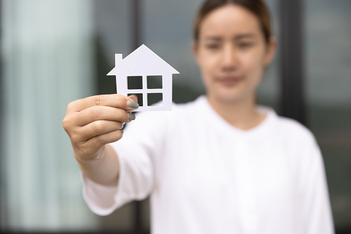woman holding a house model. Property investment and house mortgage financial real estate concept