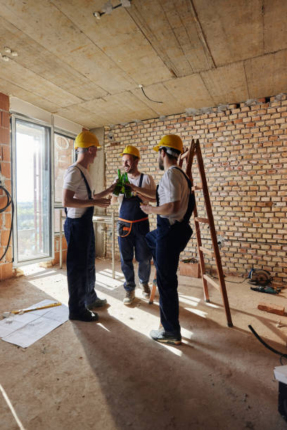 Happy manual workers toasting on a break at construction site. Happy workers toasting with beer during lunch break at construction site. Copy space. construction lunch break stock pictures, royalty-free photos & images