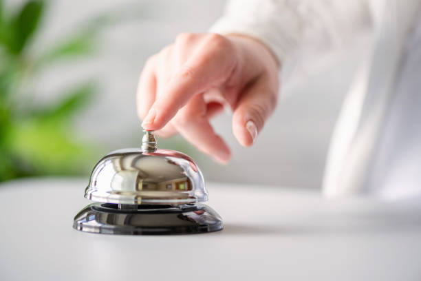 istock Hand of guest ringing in silver bell. reception desk with copy space. Hotel service. Selective focus 1408203191