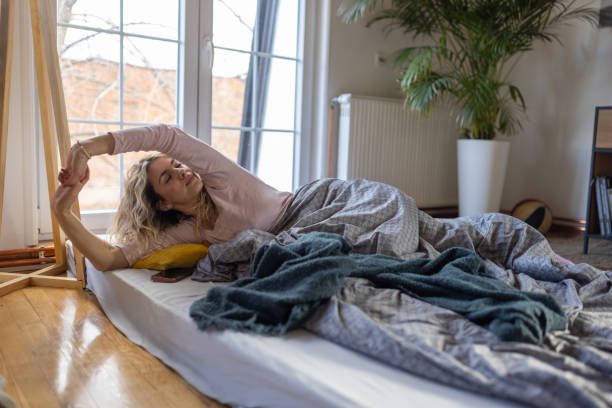 istock Young Caucasian woman stretching while waking up in the morning 1408206466