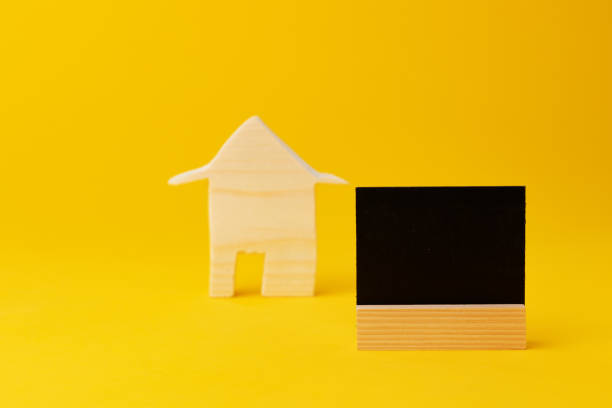 istock Wooden mini house model on yellow background 1408209178