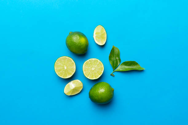 istock Lime fruits with green leaf and cut in half slice isolated on white background. Top view. Flat lay with copy space 1408209930