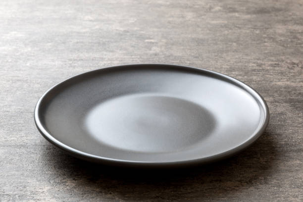 istock Perspective view of empty grey plate on cement background. Empty space for your design 1408210796