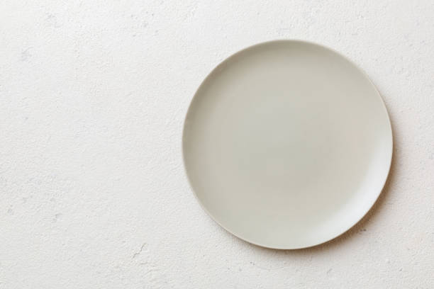 istock Top view of empty light plate on cement background. Empty space for your design 1408210845