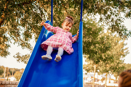 Little girl having fun on playground slide