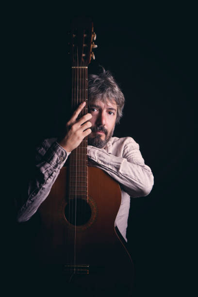 istock man poses with his guitar in a studio photograph 1408213263