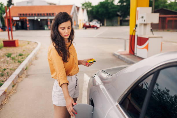 ガソリンスタンドの若い女性の写真 - gasoline car buying fuel pump ストックフォトと画像