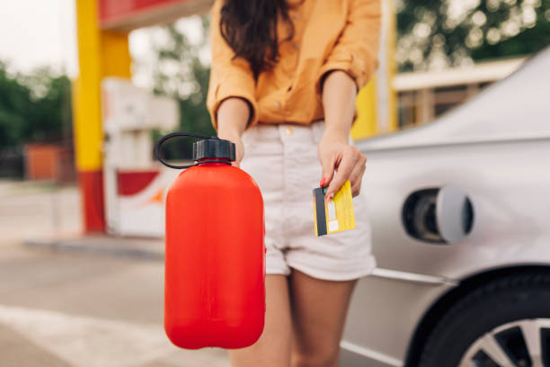 ガソリンスタンドのガソリン缶とクレジットカードを持つ女性のクローズアップ - gasoline car buying fuel pump ストックフォトと画像