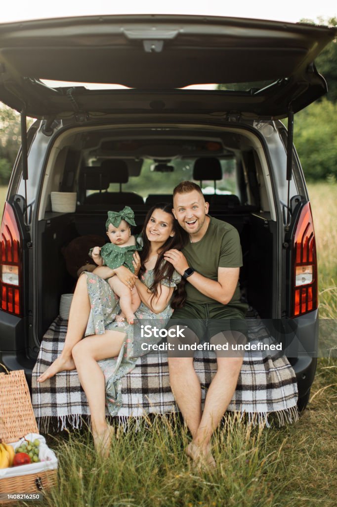 Pria dan wanita bule cantik duduk berpelukan dengan putri kecil mereka yang lucu di bagasi mobil - Bebas Royalti 25-29 tahun Foto Stok Pria dan wanita bule cantik duduk berpelukan dengan putri kecil mereka yang lucu di bagasi mobil - Bebas Royalti 25-29 tahun Foto Stok