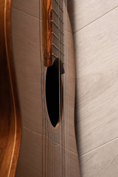 istock Classical guitar sound hole and strings up close on a light wood background 1408216398