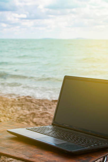 istock freelancer workplace on the sandy beach with a computer on the table. against the backdrop of the ocean and blue sky 1408217734