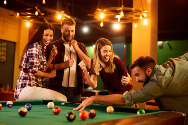 istock Group of friends having fun while playing pool in a local pool hall 1408221227