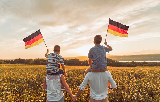A Patriotic family waving Germany flag on sunset