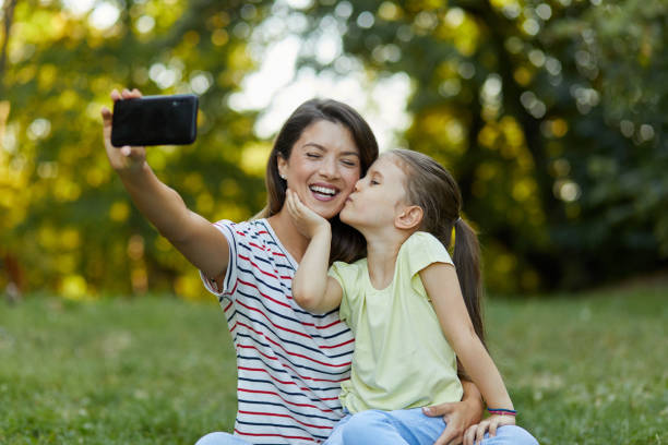 Mother and daughter taking Selfie in the park stock photo