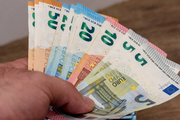 istock Man holding euro coin 1408222378