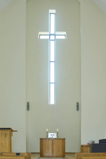 istock Empty service hall in modern catholic or evangelical church with cross on wall 1408224328