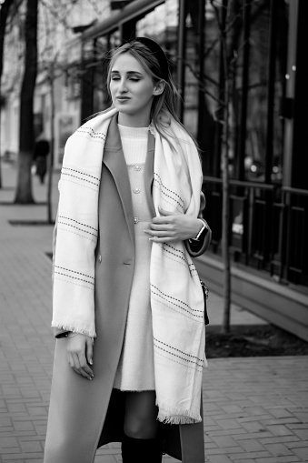 beautiful caucasian girl in a fur coat and hat walks around the city. Business concept. Business lady