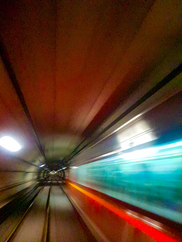 Subway train passing at high speed and leaving a trail of light.