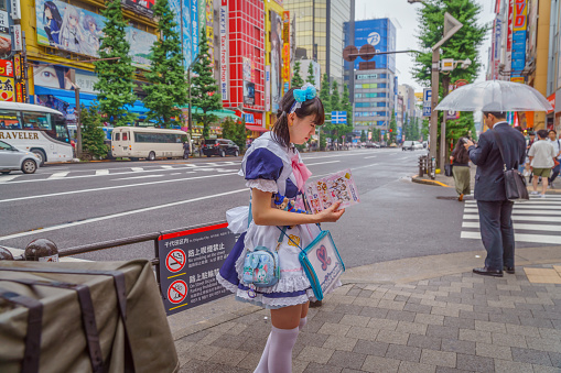 Tokyo, Japan-September 15, 2018: Young Japanese women dressed as maids promote the iconic maid cafes in Akihabara, an area known for its popular maid cafes, gaming and many electronic shops.
